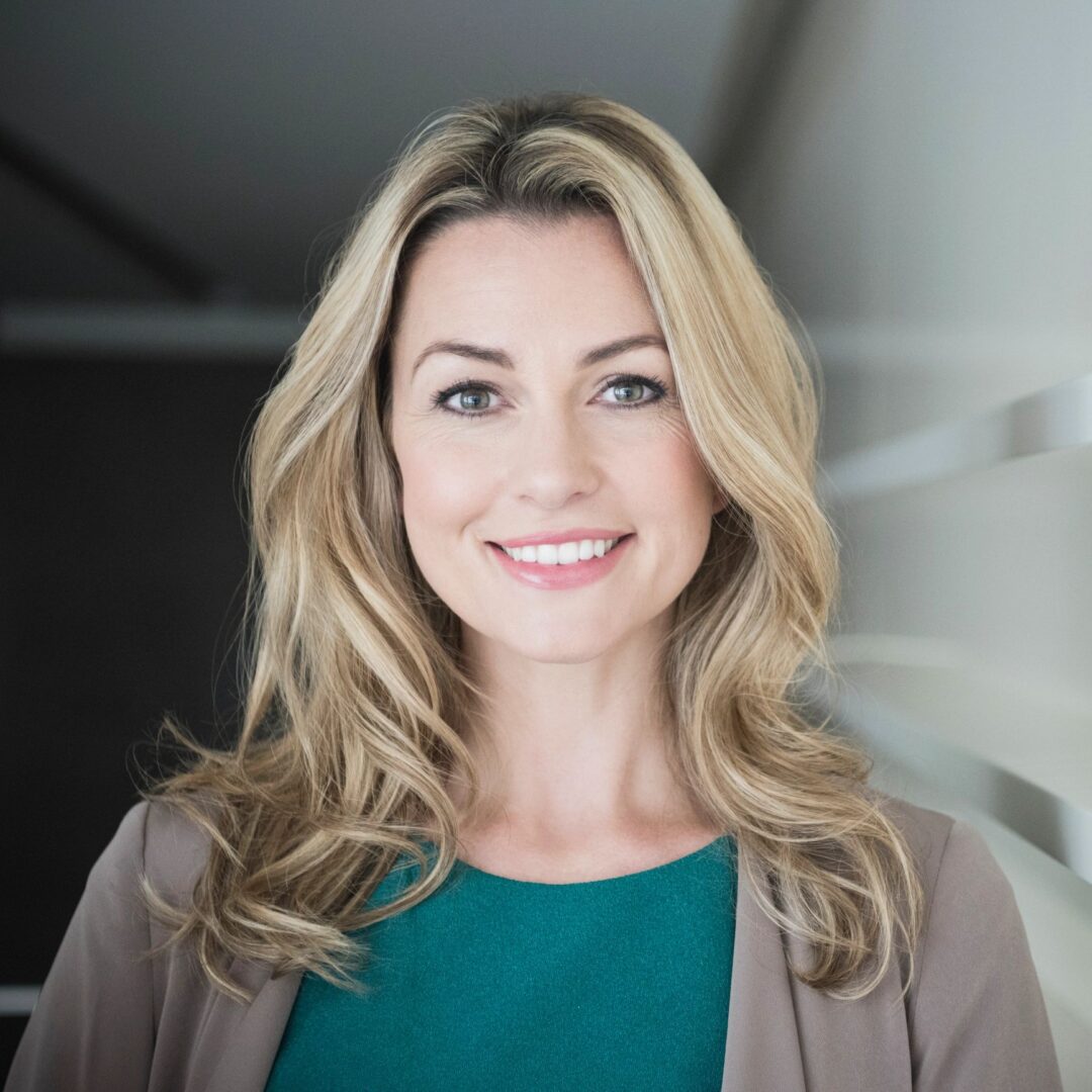 Woman in green top smiling brightly