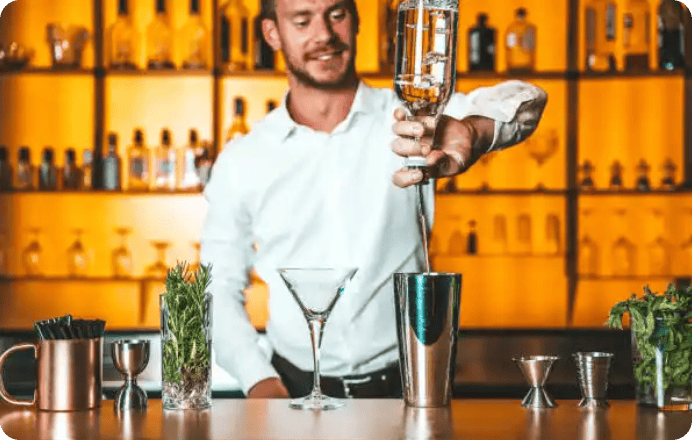 Bartender pouring liquor into cocktail shaker