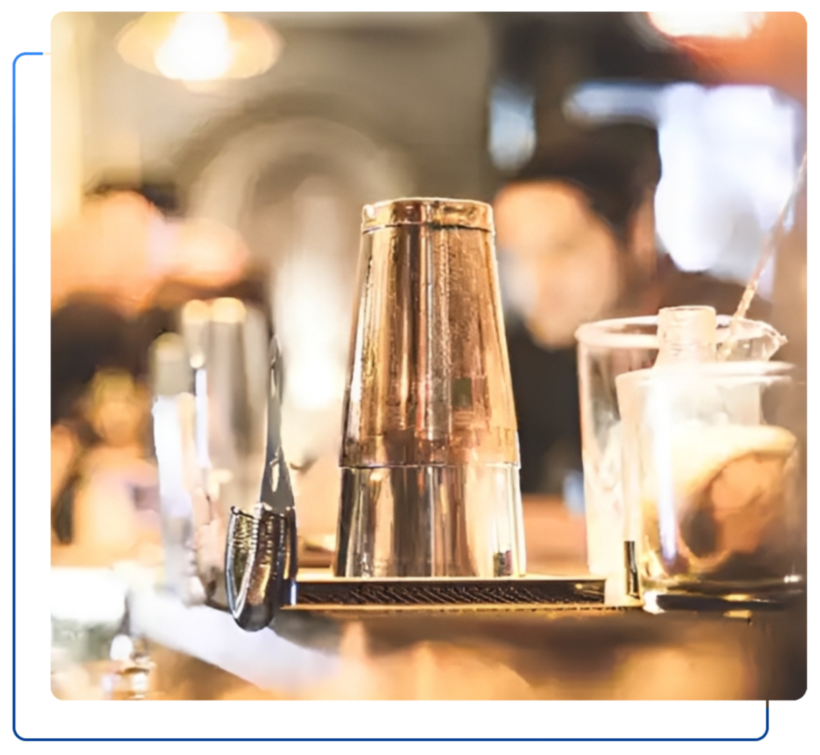 Cocktail shaker and glass on bar counter