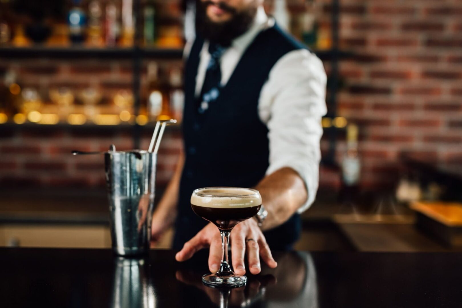 Bartender serving espresso martini on bar